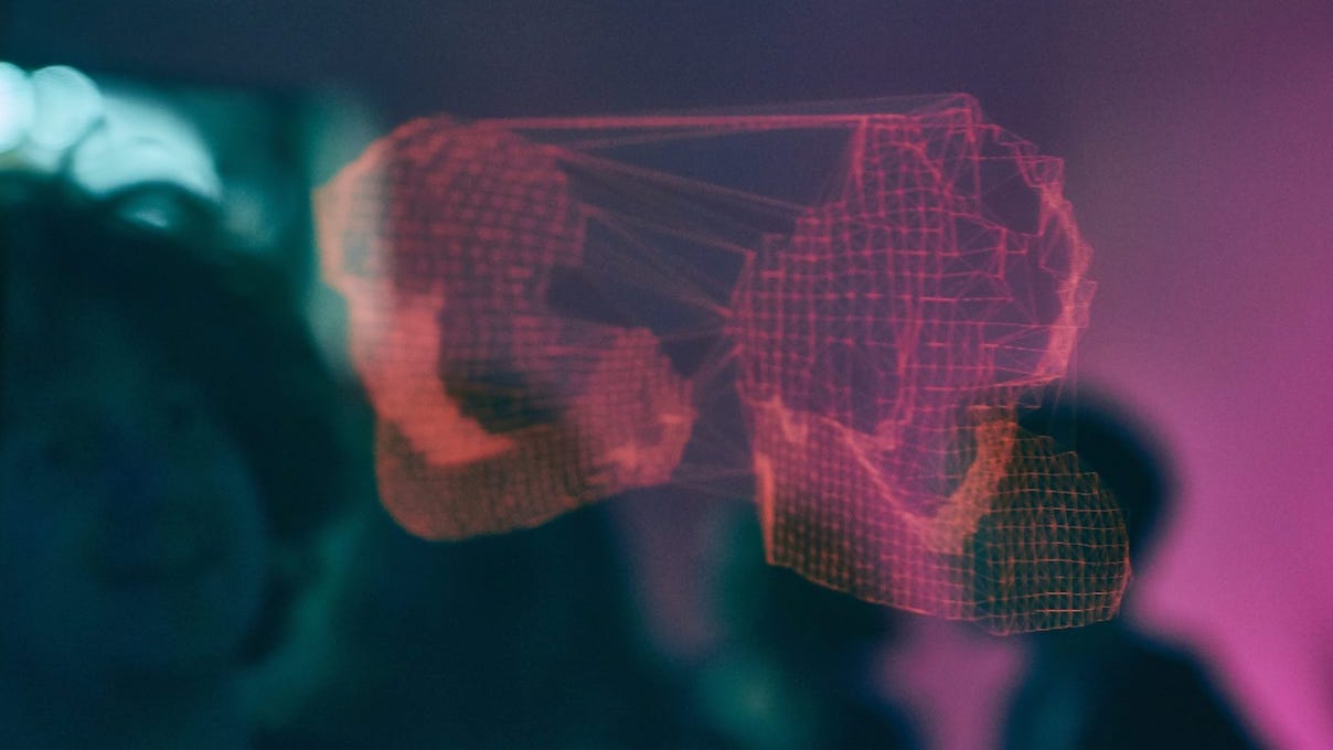 Viewer looking into a double sided mirror, behind one side is a
            screen with a digital representation of one's self